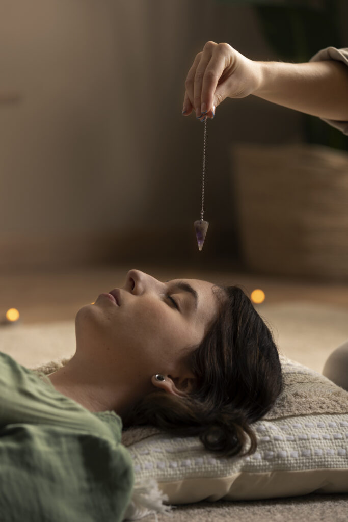 Reiki healer performing energy healing on a woman lying down