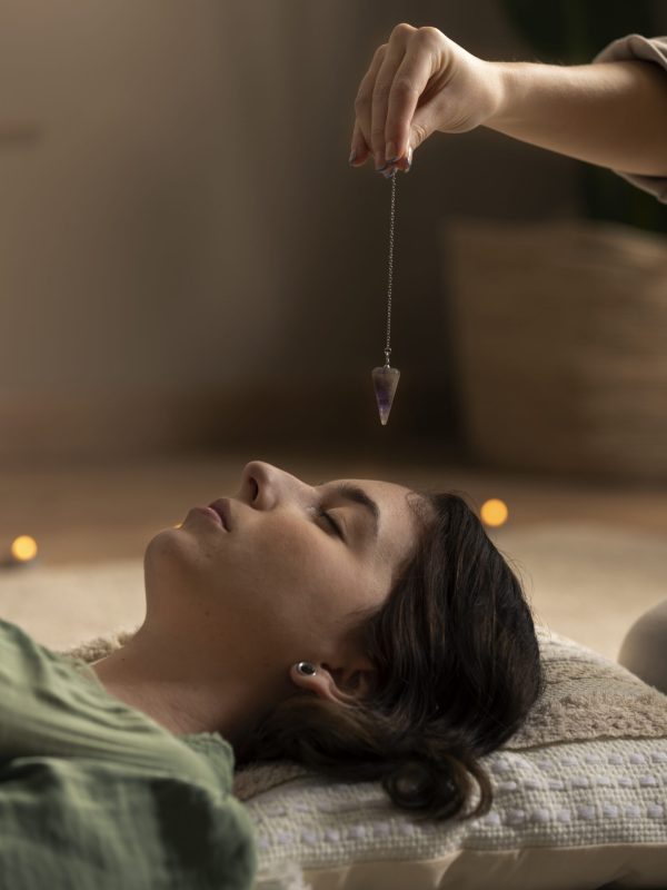 Reiki healer performing energy healing on a woman lying down