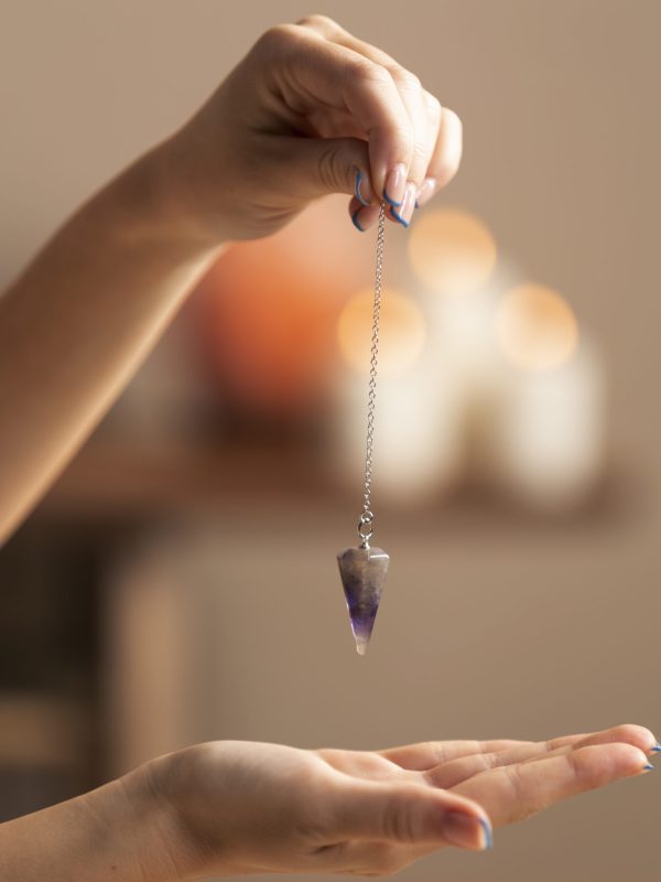 Person performing crystal healing therapy with a clear quartz crystal